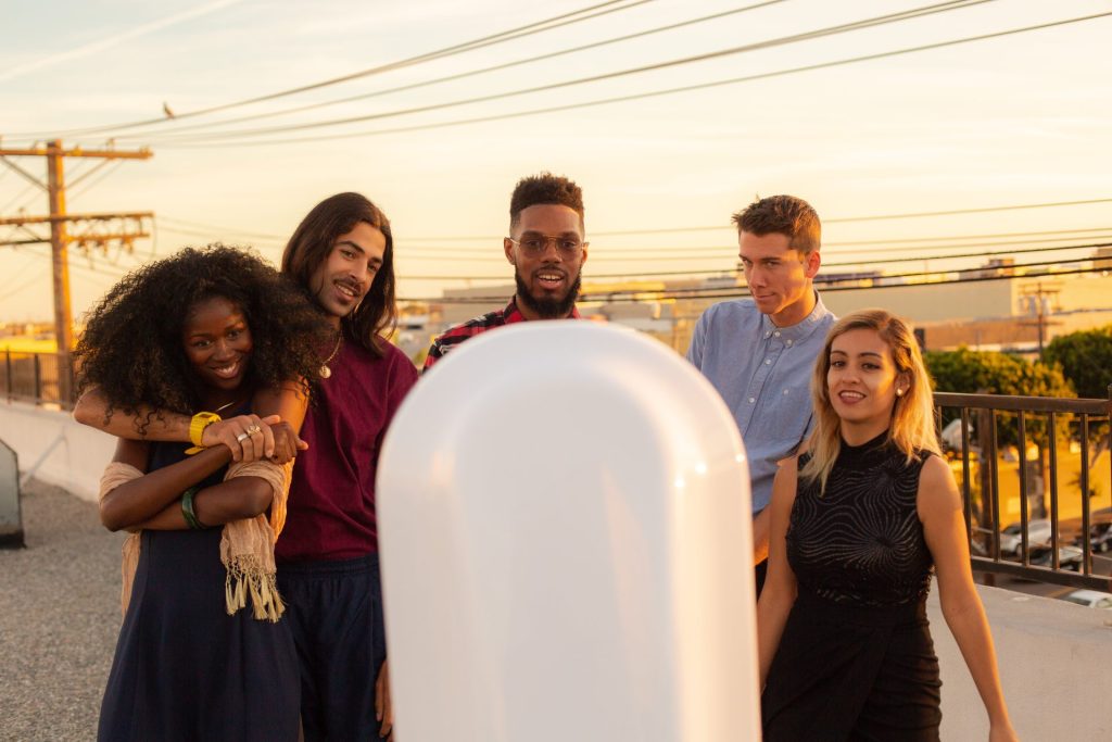 Group interacting with a photo booth at sunset