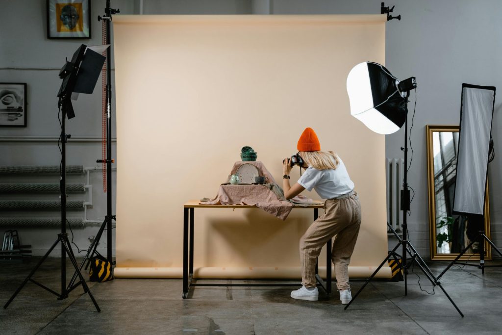 Photographer capturing ceramic pieces in a studio setting with professional lighting.